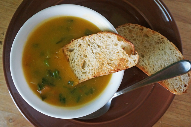 Butternut squash soup with ham and scallions -- and now a dunker of toasted bread softening in it!