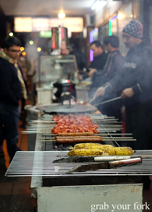 Grilled corn and bbq skewers cooking over charcoal at the Ramadan food festival in Lakemba Sydney