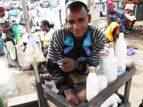 Man sells raw milk along railway tracks in Côte d'Ivoire
