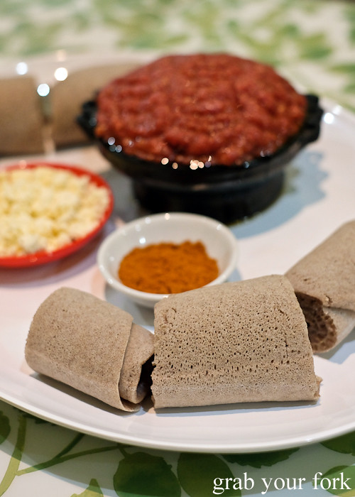 Injera Ethiopian bread with ayib cottage cheese, chilli pepper and kitfo raw beef at Aaboll Cafe, Merrylands